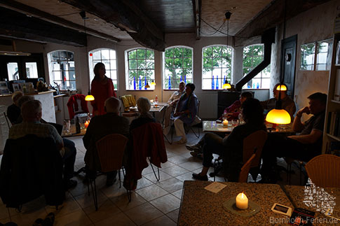 Gebannt hören die Besucher der Märchenerzählerin in Dines Lille Cafe zu, Bornholm